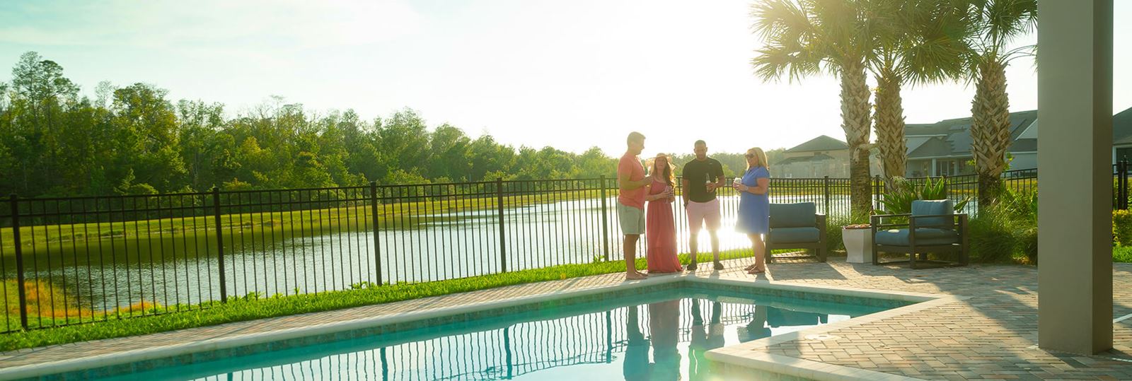 Friends relax by the pool in a new home at Bexley in Land O’ Lakes